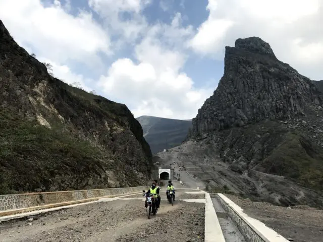 Wisatawan melintasi jalan yang melewati area Tebing Sumbing, salah satu puncak tertinggi Foto by Google Maps Syamsul Arifin, Informasi Umum, Rute Menuju Wisata Gunung Kelud, Harga Tiket Wisata Gunung Kelud, Jam Operasional, Rute Pendakian Gunung Kelud, Fasilitas Gunung Kelud, Wisata Gunung Kelud, Sumber Air Panas Gunung Kelud, Tips Wisata Gunung Kelud