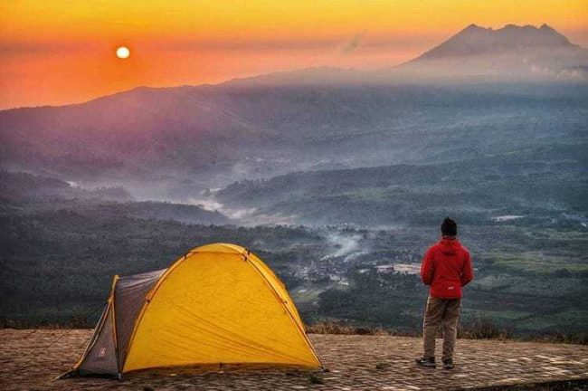 Bukit Gantole Cililin via IG @bazzonesia, 1. Mari mulai dari atraksi wisata populer di Bandung yang bisa kalian jajal dengan harga minimalis, bahkan ada yang gratis lho! Misalnya saja aneka taman tematiknya yang keren, 2. Dengan 10 ribu rupiah, kalian bisa mengelilingi kota Bandung sambil bergaya keren di atas Bus Bandros, 3. Salurkan hasratmu jadi koboi dengan naik kuda. Harganya mulai dari 5 ribuan saja lho, 4. Ingin tahu seperti apa suasana pasar terapung? Nggak usah jauh-jauh ke Thailand karena di Bandung pun ada Floating Market, 5. Terkadang, wisata murah bisa begitu dekat dengan bintang. Nggak percaya? Mampir saja ke Observatorium Bosscha yang ada di bilangan Lembang untuk membuktikannya, 6. Walau bukan obyek wisata mayor, Cagar Alam Junghuhn layak untuk dikunjungi oleh kalian yang menghargai jasa para pahlawan, 7. Air terjun Maribaya selalu menjadi favorit bagi mereka yang mencintai suasana alam dengan budget yang ekonomis, 8. Dan, dari Maribaya, kalian bisa langsung menuju Taman Hutan Raya Juanda. Harga tiketnya sama ekonomisnya lho, 9. Untuk melengkapi kunjungan di Taman Hutan Raya Juanda, sekalian saja mampir ke tempat selfie paling populer di Bandung, yaitu Tebing Keraton, 10. Menikmati sejuknya udara Bandung bisa kalian lakukan sambil mengenal ragam fauna di Kebun Binatang Bandung, 11. Area Bandung Selatan juga punya banyak obyek wisata yang menyayangi kantong kalian. Misalnya saja wisata Kawah Putih-nya yang super populer itu, 12. Untuk kalian para pecinta wisata alam dan pengagum nilai-nilai romantisme, Situ Patenggang menjadi tempat yang wajib kalian sambangi di Bandung, 13. Mampirlah ke Pemandian Air Panas Cibolang yang akan menghangatkan tubuh kalian dari gigitan udara dingin di Ciwidey, 14. Cibolang bukan satu-satunya tempat yang dapat menghangatkan tubuh kalian saat dingin. Kunjungi saja Taman Wisata Alam Cimanggu yang juga menawarkan kolam pemandian air panas alami, 15. Atau, mampirlah ke pemandian Air Panas Alami Walini/Rancawalini juga populer di wilayah Ciwidey. Kalian dapat menikmati suasana berendam air panas di tengah perkebunan teh, 16. Wisata di Ciwidey akan semakin lengkap jika kalian berjalan-jalan di tengah Perkebunan Teh Rancabali. Pemandangannya yang indah akan membuat siapapun mendadak suka mengambil foto, 17. Untuk menutup wisata hemat di Bandung, mampirlah ke Pasar Gedebage untuk belanja pakaian second berkualitas bagus. Harganya? Murah meriah!, 18. Balitsa Lembang yang Instagramable, 19. Keindahan Babakan Siliwangi yang bikin mata terpana, 20. Mengintip Dinosaurus di Museum Geologi, 21. Kawah Rengganis yang begitu eksotis, 22. Epic Sunrise di Venue Gantole Cililin, 23. Menikmati pesona alam hijau di Bukit Teletubies, 24. Menikmati pesona alam hijau khas bebukitan di Bukit Jamur, 25. Pesona Curug Bellarosa yang bikin pikiran adem, 26. Epiknya pemandangan di Gunung Nini Pangalengan