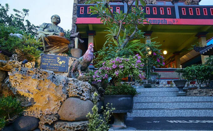 Ayam Betutu Men Tempeh Gilimanuk 23 Tempat Wisata Kuliner di Bali Paling Legendaris &amp; Terbaik, Enak, 1. Sop Ikan Mak Beng Sanur, 2. Warung Mami, 3. Warung Wardani, 4. Sate Plecing Arjuna, 5. Warung D’Sawah, 6. Sanur Night Market, 7. Warung Nyoman, 8. Nasi Ayam Kedewatan Ibu Mangku, 9. Bebek Bengil Crispy Duck – Nusa Dua, 10. MamaSan Bali, 11. Nasi Pedas Bu Andika, 12. Rujak Kuah Pindang Bu Putu, 13. Revolver Espresso, 14. Seniman Coffee, 15. Bebek Goreng Laka Leke, 16. Warung Nasi Bali Men Weti (Sanur), 17. Naughty Nuri’s Warung, 18. Ayam Betutu Men Tempeh Gilimanuk, 19. Warung Laota, 20. Warung Bebek Tepi Sawah, 21. Sate Babi Bawah Pohon (Kuta), 22. Nasi Pecel Bu Tinuk, 23. Warung Liku