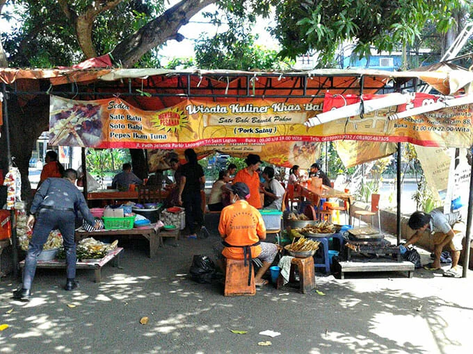 Sate Babi Bawah Pohon (Kuta) 23 Tempat Wisata Kuliner di Bali Paling Legendaris &amp; Terbaik, Enak, 1. Sop Ikan Mak Beng Sanur, 2. Warung Mami, 3. Warung Wardani, 4. Sate Plecing Arjuna, 5. Warung D’Sawah, 6. Sanur Night Market, 7. Warung Nyoman, 8. Nasi Ayam Kedewatan Ibu Mangku, 9. Bebek Bengil Crispy Duck – Nusa Dua, 10. MamaSan Bali, 11. Nasi Pedas Bu Andika, 12. Rujak Kuah Pindang Bu Putu, 13. Revolver Espresso, 14. Seniman Coffee, 15. Bebek Goreng Laka Leke, 16. Warung Nasi Bali Men Weti (Sanur), 17. Naughty Nuri’s Warung, 18. Ayam Betutu Men Tempeh Gilimanuk, 19. Warung Laota, 20. Warung Bebek Tepi Sawah, 21. Sate Babi Bawah Pohon (Kuta), 22. Nasi Pecel Bu Tinuk, 23. Warung Liku
