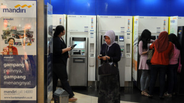 Nasabah saat mengambil uang di Anjungan Tunai Mandiri (ATM) Bank Mandiri.