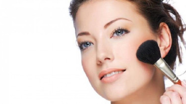 Wanita pakai blush on.