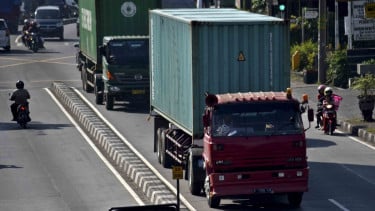 Ilustrasi truk dan kendaraan berat melintas di jalan raya.