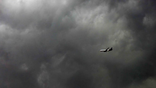 Sebuah pesawat berusaha melewati awan tebal yang menyelimuti kota Makassar saat akan mendarat di Makassar, Sulawesi Selatan