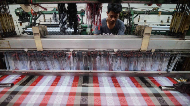 Pekerja menyelesaikan produksi kain sarung di Pabrik Tekstil Kawasan Industri Majalaya, Kabupaten Bandung, Jawa Barat, Jumat, 4 Januari 2019.