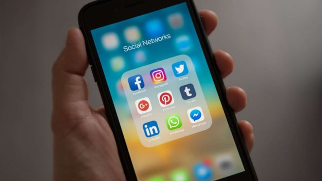 Ilustrasi menggunakan Facebook di iPhone.