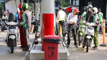 Pengemudi ojek online (ojol) sedang mengisi BBM