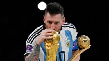 Kapten Timnas Argentina, Lionel Messi mencium trofi Piala Dunia 2022.