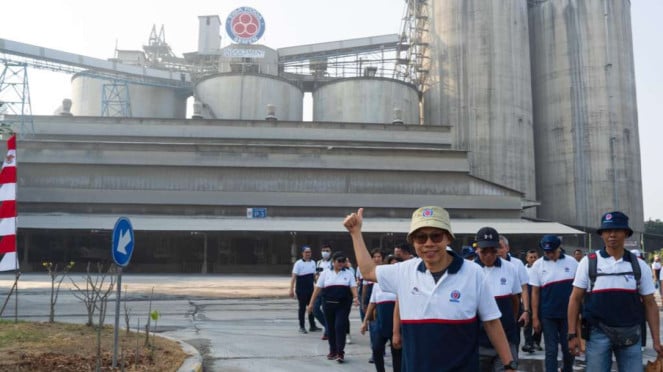 Sejumlah karyawan dengan latar belakang pabrik semen Indocement di Bogor, Jawa B