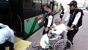 Petugas haji sedang membantu jemaah menaiki Bus Shalawat di Mekah