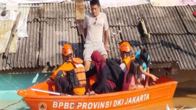 Petugas saat mengevakuasi warga terdampak banjir di Jakarta, Minggu (6/7/2025).