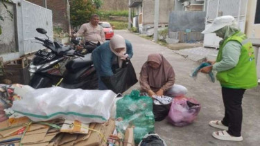 Warga memilih sampah dari rumah.
