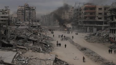 Warga Gaza berjalan di tengah puing reruntuhan bangunan saat gencatan senjata