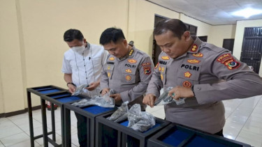 Pejabat Polda NTT memeriksa pistol yang sempat hilang ditemukan di Bali