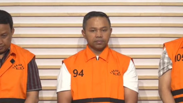 Gubernur Riau Abdul Wahid (tengah) pakai rompi oranye dan tangan diborgol