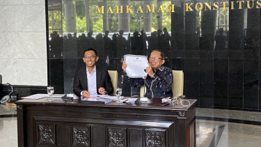 Hakim Konstitusi Arsul Sani (kanan) memperlihatkan ijazah aslinya