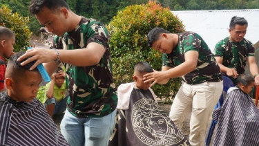Prajurit TNI Bantu Cukur Rambut Gratis Anak Pengungsi Bencana di Tapanuli Utara