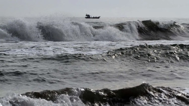 Kapal nelayan melintas disaat cuaca buruk gelombang laut tinggi