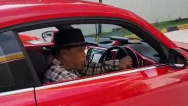 Eggi Sudjana menyetir mobil mewah di sebuah SPBU di Malaysia