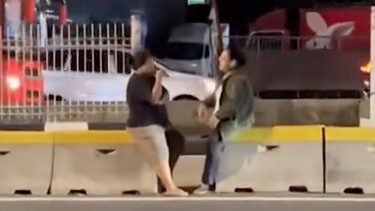 Emak-emak asyik ngobrol di pembatas jalur busway