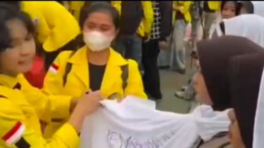 Mahasiswi melakukan pencoretan terhadap penutup kepala (jilbab) seorang Polwan