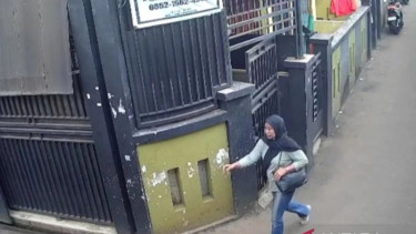 Wanita mengambil uang takziah di rumah duka di Jalan Dukuh IV, Kampung Dukuh, Kramat Jati, Jakarta Timur