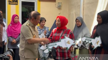 Gubernur DKI Jakarta Pramono Anung memberikan simbolis kunci hasil program bedah rumah kepada warga