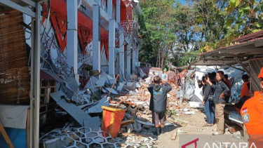 Sejumlah orang di dekat reruntuhan gedung KONI Sario Manado, Sulawesi Utara, pascagempa bumi