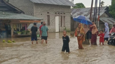 Warga di Kecamatan Sirenja, Kabupaten Donggala, Sulteng berjalan di tengah banjir