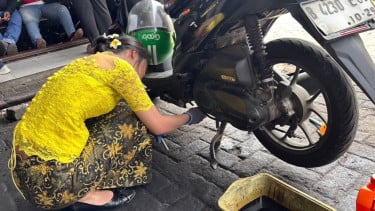 Seorang wanita ganti oli motor di Hari Kartini