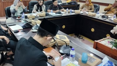 Anggota DPRD Jember Achmad Syahri Assidiqi sedang bermain game sembil merokok di tengah jalannya rapat tentang kesehatan