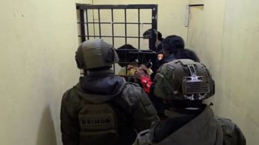 Personel Polri dari Satgas ODC saat mengiring YM masuk ke dalam sel tahanan di Polres Puncak