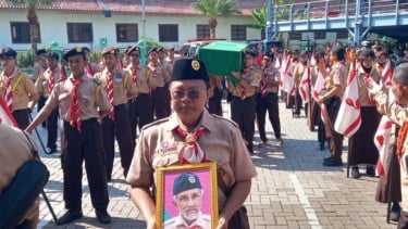 Anggota Pramuka mebawa foto sosok Kaka Herman Sulistyo dalam prosesi upacara pemakaman almarhum di Kota Tangerang