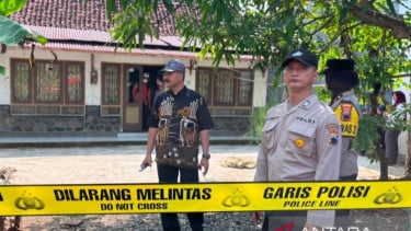 Polisi berjaga di depan rumah lokasi penemuan dua mayat perempuan di Desa Patikraja, Banyumas
