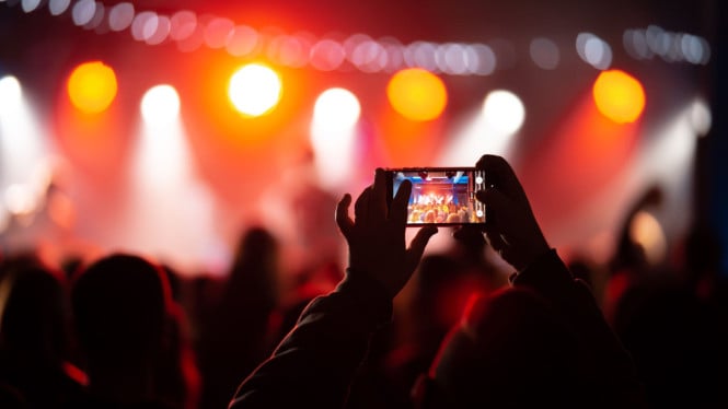 Ilustrasi rekam video di konser/foto/memotret/merekam, 1. Atur Resolusi dan Frame Rate Video, 2. Aktifkan Fitur HDR Video, 3. Gunakan Format Video HEVC, 4. Stabilkan Video dengan Fitur Cinematic dan Action Mode, 5. Manfaatkan Cahaya yang Cukup, 6. Gunakan Lensa Tambahan (Optional), 7. Periksa dan Bersihkan Lensa Kamera, 8. Edit Video dengan Aplikasi Bawaan atau Tambahan