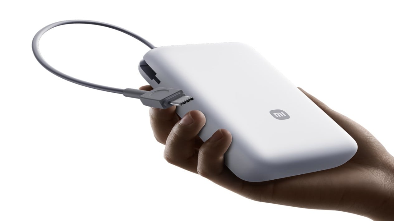 Detail port USB dan lampu indikator LED pada power bank Xiaomi terbaru., Tampilan bagian depan power bank Xiaomi 20000 mAh terbaru dengan kabel USB-C terintegrasi., Desain Kabel USB-C Terintegrasi Yang Memudahkan Mobilitas Harian, Detail port USB dan lampu indikator LED pada power bank Xiaomi terbaru., Inovasi Fitur Kesehatan Baterai Untuk Masa Pakai Lebih Lama, Standar Keamanan Baru Untuk Penggunaan Yang Lebih Tenang, Potensi Rilis Resmi Di Indonesia