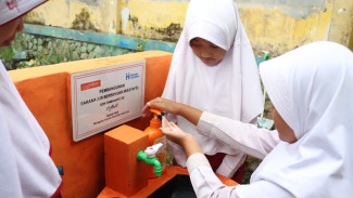 Anak sekolah cuci tangan.