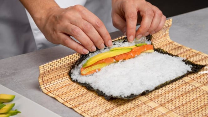 Ilustrasi menggulung Kimbap, 1. Gunakan Nasi yang Tepat, 2. Jangan Isi Terlalu Banyak, 3. Gunakan Alas Gulung atau Plastik Wrap, 4. Rapikan Gulungan dengan Sedikit Air, 5. Dinginkan Sebentar Sebelum Dipotong, 6. Gunakan Pisau Tajam dan Basahi Ujungnya, 7. Lap Pisau Setiap Beberapa Potongan