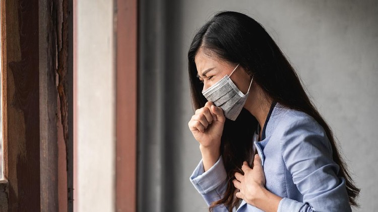 COVID-19 Pandemic Coronavirus&comma; Asian woman wearing a mask&comma; have a symptoms coughing and fever
