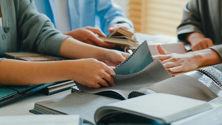 Close-up of Asian tenants choose colors&comma; patterns&comma; and materials and give them to female interior designer for new house&period; Happy couple buy real estate for investment concept&period;