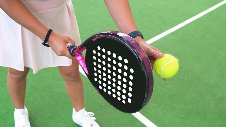 Close-up shot of unrecognizable woman ready to serve ball during padel tennis games on indoor court., Apa itu olahraga padel?, Perbedaan olahraga padel dan tenis, Asal usul olahraga padel, Awal mula padel terkenal hingga sejumlah artis RI ikutan, 5 Lapangan tempat main padel di Jakarta