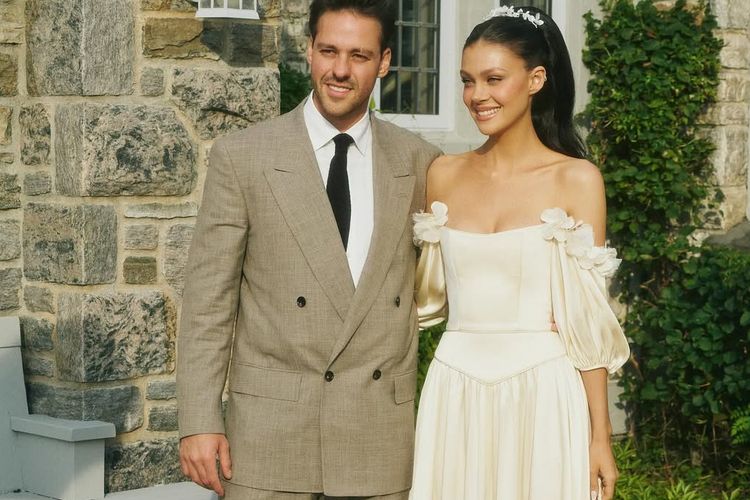 Brooklyn Beckham, Nicola Peltz, nicola peltz gaun vintage, 7 Detail Gaya Nicola Peltz Saat Pembaruan Janji Nikah, Pakai Gaun 1980-an Milik Ibu, 1. Gaun off-the-shoulder, 2. Body korset yang anggun, 3. Rok panjang jatuh natural, 4. Detail bunga pada lengan, 5. Tatanan rambut dan makeup, 6. Aksesori sederhana namun elegan, 7. Busana Brooklyn Beckham