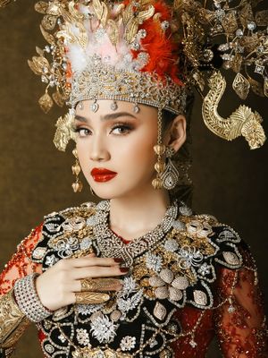 7 Detail Busana Adat Gorontalo Syifa Hadju dan El Rumi saat Prewedding, Serba Merah, 1. Dominasi warna merah yang menjadi pusat perhatian, 2. Mahkota tinggi dengan ornamen emas pada busana Syifa, 3. Detail payet penuh di bagian dada dan bahu, 4. Lengan transparan dengan payet merah, 5. Sabuk emas lebar sebagai penegas siluet, 6. Busana El Rumi bergaya formal dengan aksen emas, 7. Perpaduan keseluruhan tampak serasi dan berkarakter
