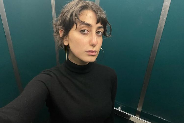 Rama Duwaji, Zohran Mamdani, zohran mamdani wali kota new york, rama duwaji, zohran mamdani dan rama duwaji, gaya busana rama duwaji, style rama duwaji, wali kota new york terpilih, 8 Gaya Rama Duwaji Istri Zohran Mamdani, Minimalis dan Artsy, 1. Dress putih bertekstur dengan boots hitam, 2. Tank top hitam dan rok flare bermotif, 3. One shoulder crop top dengan belt, 4. Midi dress hitam dengan tas selempang krem, 5. Atasan putih tanpa lengan dan layered necklace, 6. Tank top hijau zaitun, 7. Tank top hitam dan celana hitam bertekstur, 8. Turtleneck hitam dan anting besar