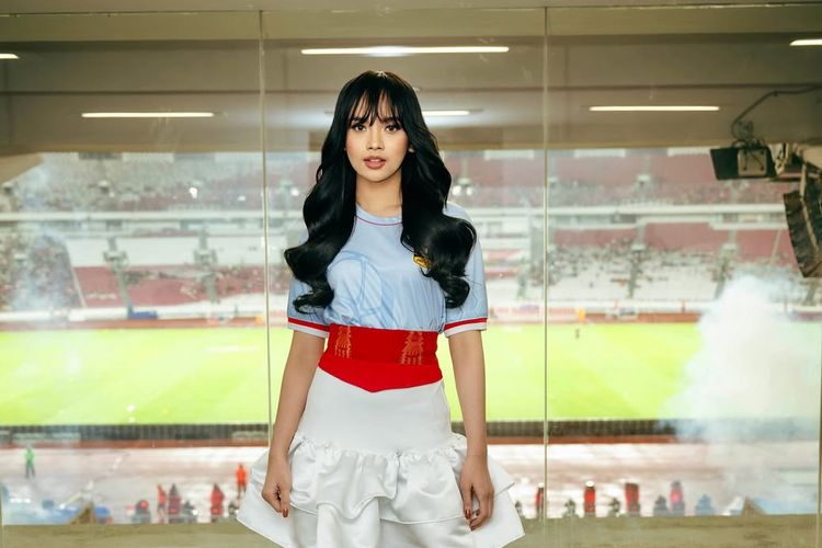 Lyodra Ginting, Piala Presiden 2025, penampilan lyodra di piala presiden 2025, gaya Lyodra di Piala Presiden 2025, Lyodra Padukan Jersey dan Rok Ruffle di Piala Presiden 2025, Intip Detail Outfitnya, 1. Jersey Biru, 2. Mini skirt ruffle putih, 3. Obi etnik merah, 4. Boots, 5. Rambut wavy tergerai, 6. Makeup flawless