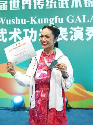 Krisdayanti, Kris Dayanti, kris dayanti wushu, krisdayanti wushu, krisdayanti raih medali perak, 7 Gaya Kris Dayanti Saat Raih Medali Perak di World Kungfu Championship, Nuansa Ceria, 1. Dominasi warna merah muda, 2. Motif bordir burung, 3. Kancing depan Shanghai style, 4. Siluet longgar yang tetap proporsional, 5. Jaket putih dengan emblem kontingen, 6. Rambut dikuncir rapi dengan makeup fresh, 7. Medali perak