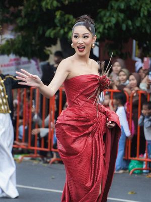 Jember Fashion Carnaval, Patricia Gouw, jember fashion carnaval 2025, patricia gouw di jember carnaval 2025, artwear carnival jfc, 7 Outfit Patricia Gouw di Jember Fashion Carnaval, Memukau Serba Merah, 1. Gaun merah, 2. Gaya rambut dan aksesori headpiece, 3. Makeup, 4. Heels transparan beraksen perak, 5. Gaun hitam-merah berlayer di Artwear Carnival, 6. Detail pita besar di bagian belakang, 7. Boots hak tinggi berwarna merah marun