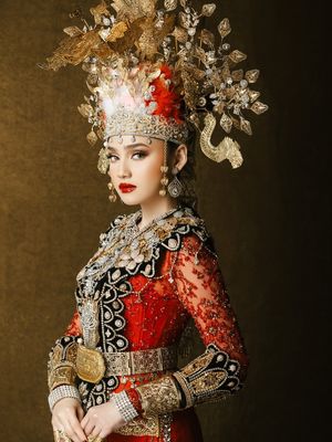 7 Detail Busana Adat Gorontalo Syifa Hadju dan El Rumi saat Prewedding, Serba Merah, 1. Dominasi warna merah yang menjadi pusat perhatian, 2. Mahkota tinggi dengan ornamen emas pada busana Syifa, 3. Detail payet penuh di bagian dada dan bahu, 4. Lengan transparan dengan payet merah, 5. Sabuk emas lebar sebagai penegas siluet, 6. Busana El Rumi bergaya formal dengan aksen emas, 7. Perpaduan keseluruhan tampak serasi dan berkarakter