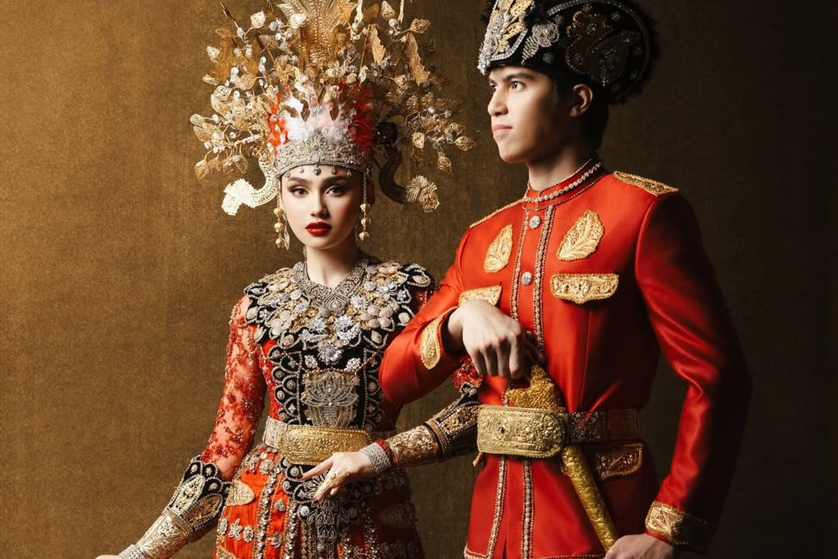 7 Detail Busana Adat Gorontalo Syifa Hadju dan El Rumi saat Prewedding, Serba Merah, 1. Dominasi warna merah yang menjadi pusat perhatian, 2. Mahkota tinggi dengan ornamen emas pada busana Syifa, 3. Detail payet penuh di bagian dada dan bahu, 4. Lengan transparan dengan payet merah, 5. Sabuk emas lebar sebagai penegas siluet, 6. Busana El Rumi bergaya formal dengan aksen emas, 7. Perpaduan keseluruhan tampak serasi dan berkarakter