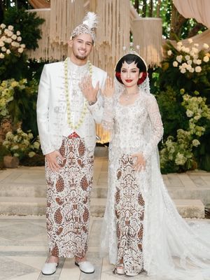 Jennifer Coppen, Justin Hubner, 5 Gaya Akad Nikah Jennifer Coppen dan Justin Hubner, Balutan Adat Jawa, 1. Jennifer tampil anggun dengan kebaya putih berhiaskan payet, 2. Riasan paes memperkuat nuansa adat Jawa, 3. Sanggul klasik dihiasi aksen bunga merah, 4. Justin Hubner tampil gagah dengan beskap putih, 5. Blangkon dan ronce melati melengkapi penampilan